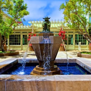 Stone architectural fountain operating after repair service in California courtyard landscape